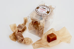 Sweet, chewy caramels, individually wrapped in unbleached parchment paper. 8 homemade caramels, individually wrapped and packaged in a clear, rectangular, food safe container with an attractive label on the front.
