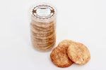 Snickerdoodle cookies.  10 cookies stacked in a clear, food safe container with an attractive table on the top.